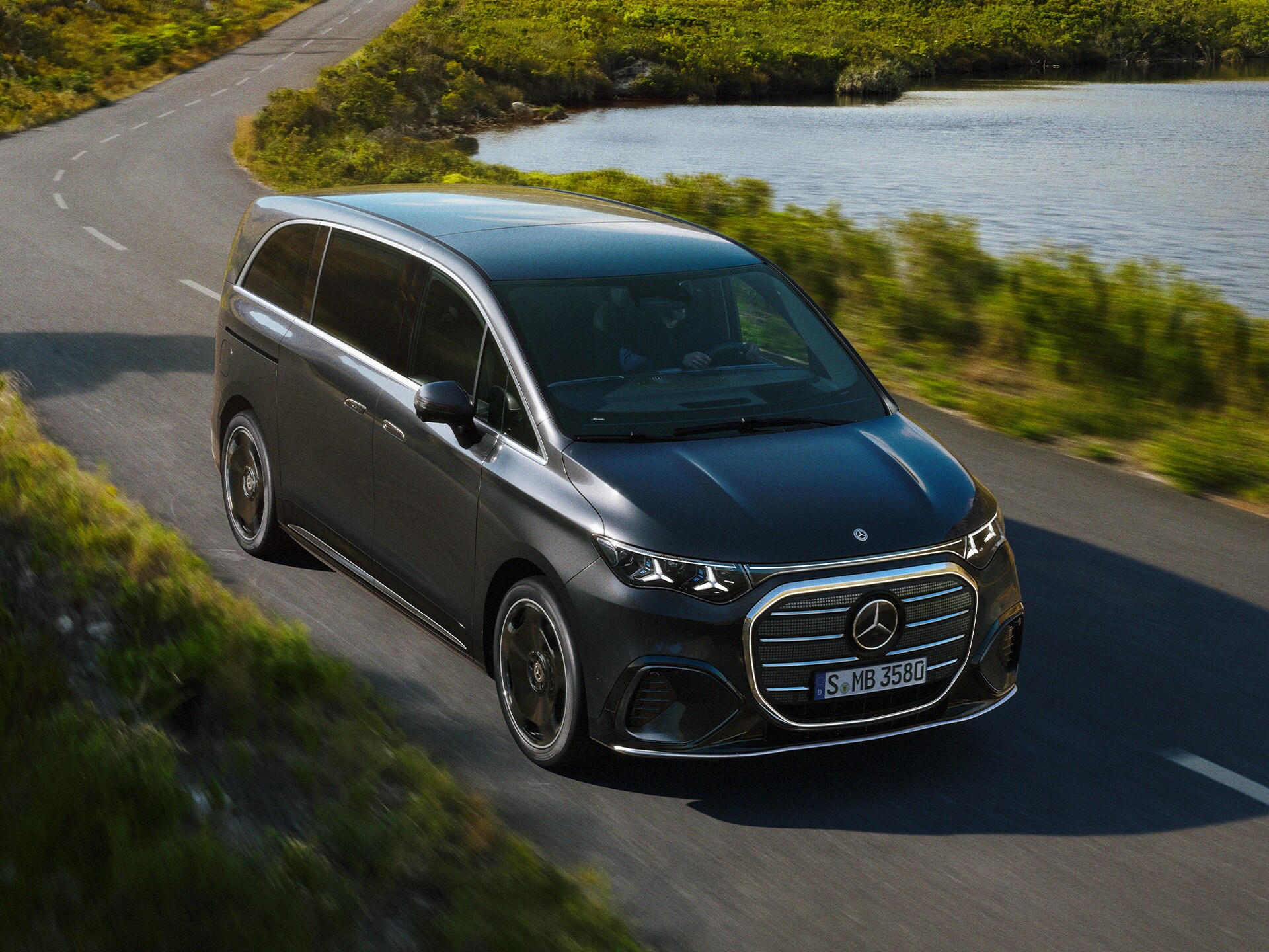 Mercedes-Benz VLE na kľukatej ceste pri jazere.