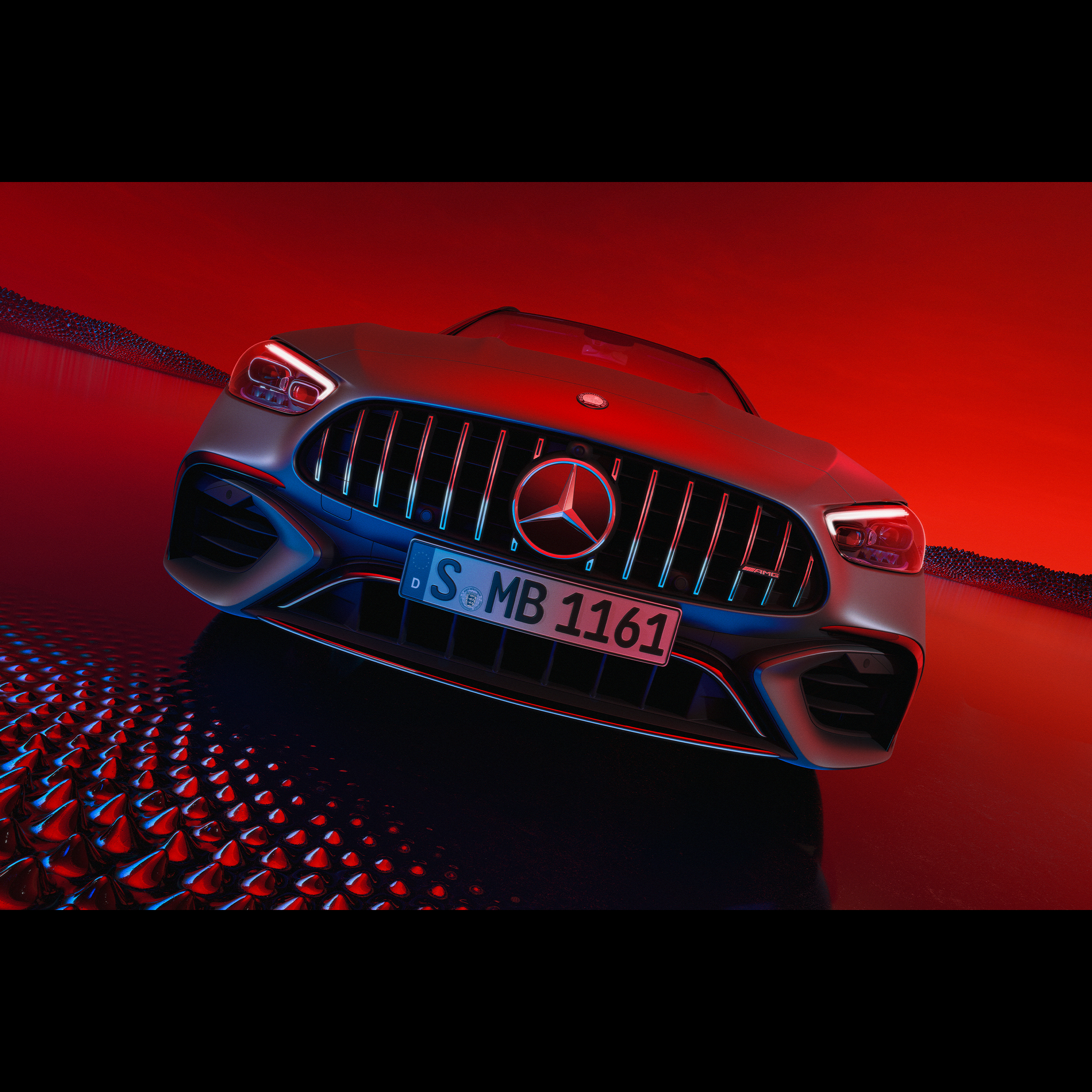 Mercedes-AMG C 63 S E PERFORMANCE pri pohľade spredu pred červeným pozadím.