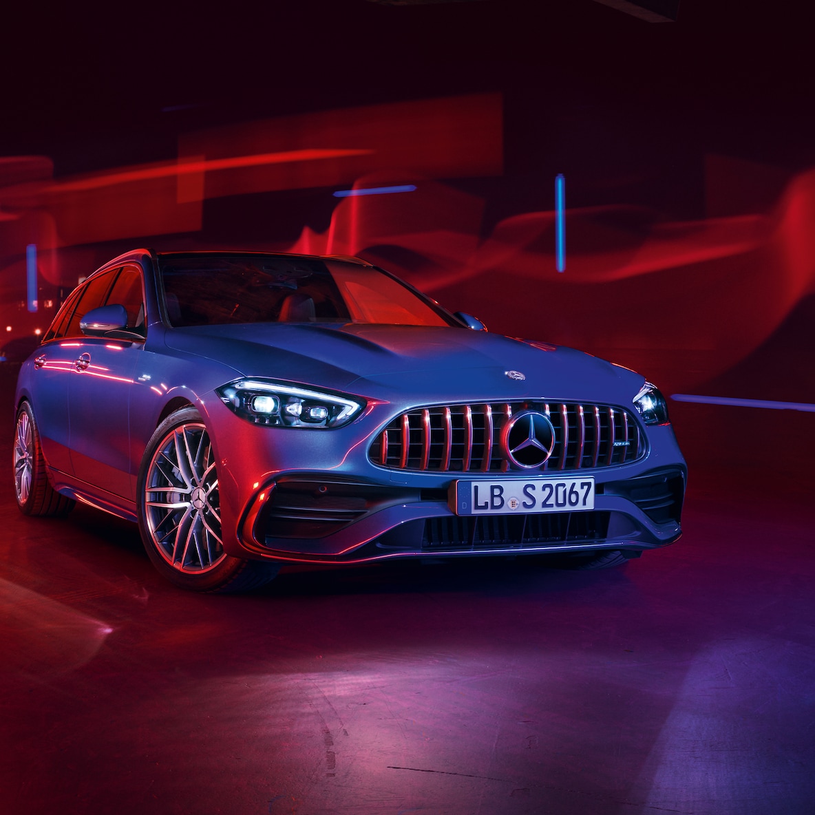 Mercedes-AMG C 43 pri pohľade spredu pred červeným pozadím.