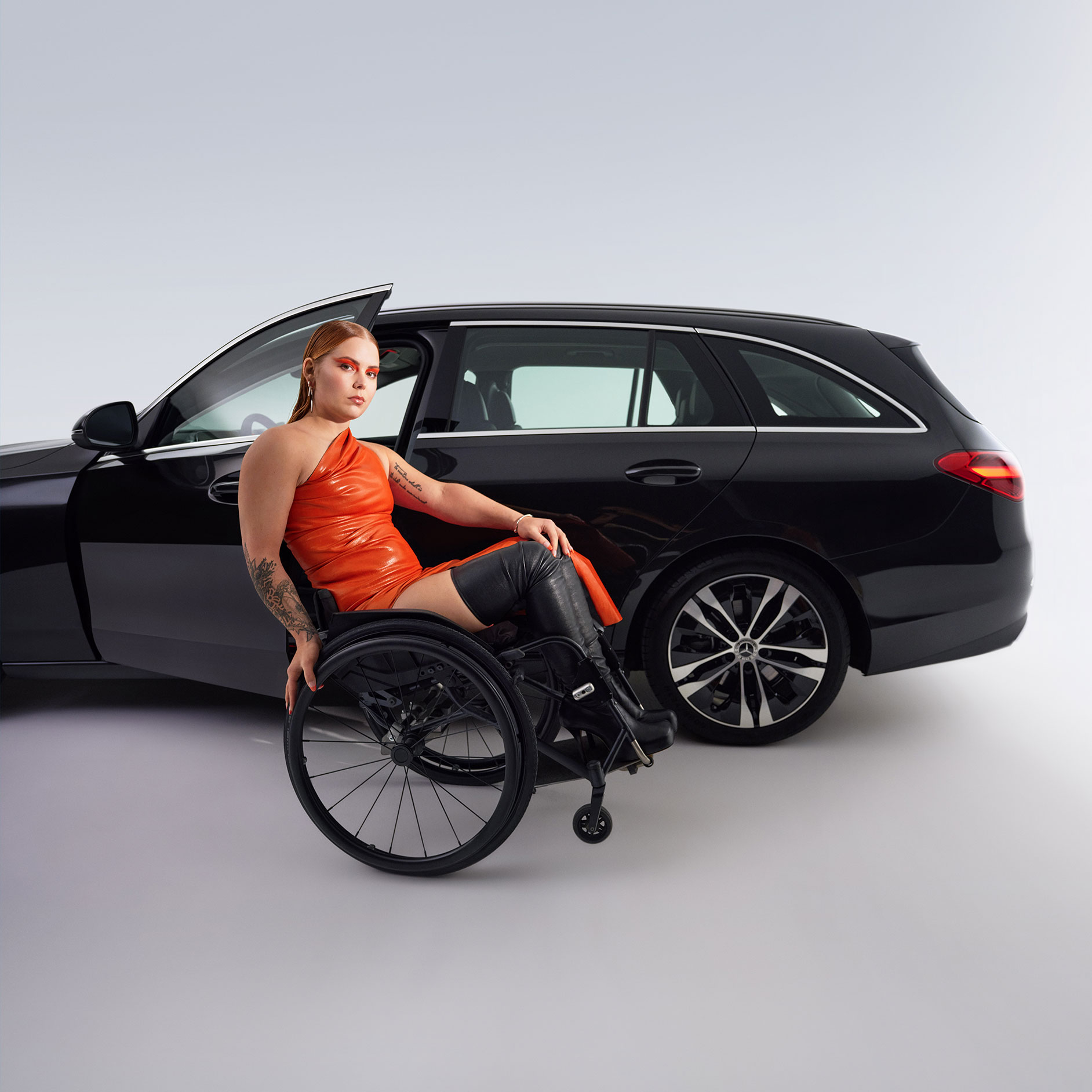 Pomôcky na nastupovanie a vystupovanie | Pomôcky na ovládanie vozidla | Mercedes-Benz Pohľad zboku na kombi Triedy C upravené na vozidlo vhodné pre invalidov a žena na invalidnom vozíku.