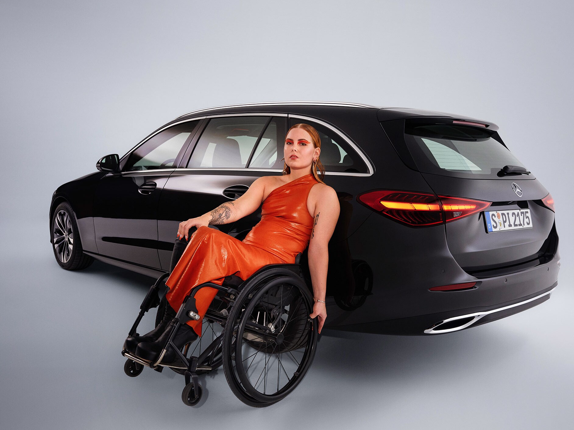 Šikmý pohľad zozadu na kombi Triedy C upravené na vozidlo vhodné pre telesne postihnutých a žena na invalidnom vozíku.