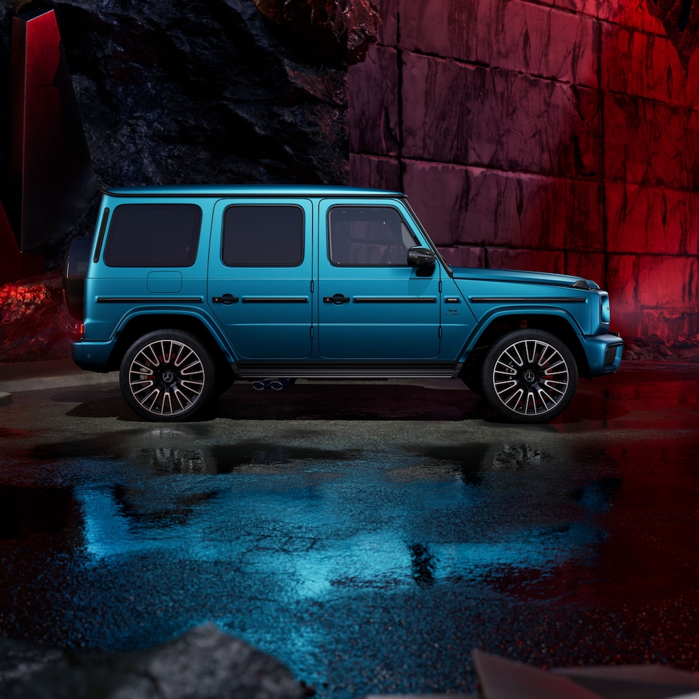 Bočný pohľad spredu na vozidlo Mercedes-AMG G 63 s lakom vo farbe modrá hyper MANUFAKTUR magno.