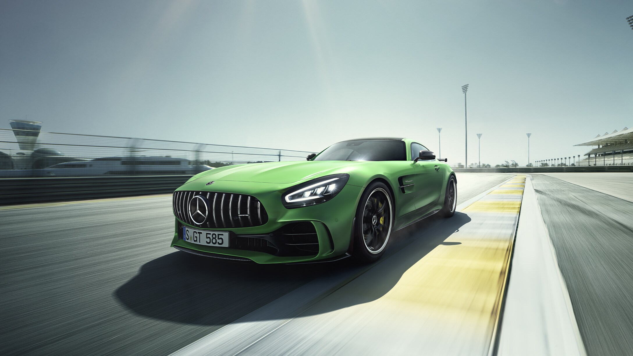 Zelený Mercedes-AMG GT R na pretekárskom okruhu bez divákov.