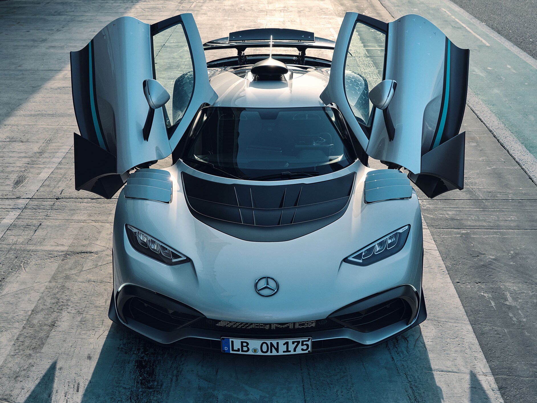Pohľad spredu na model Mercedes-AMG ONE s&nbsp;otvorenými dverami.