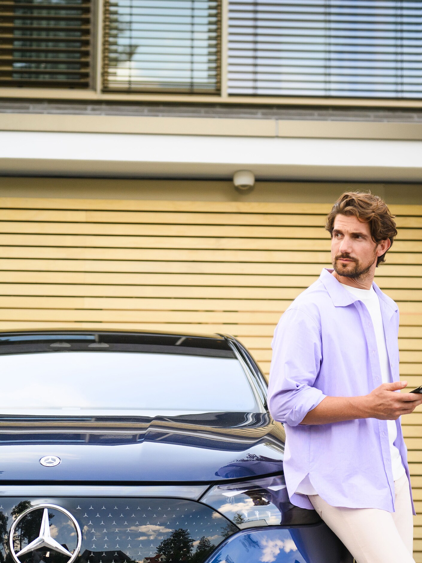 Osoba, ktorá sa opiera o vozidlo Mercedes-Benz.