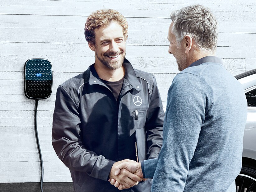Dve osoby si po úspešnej inštalácii Mercedes-Benz podávajú ruku