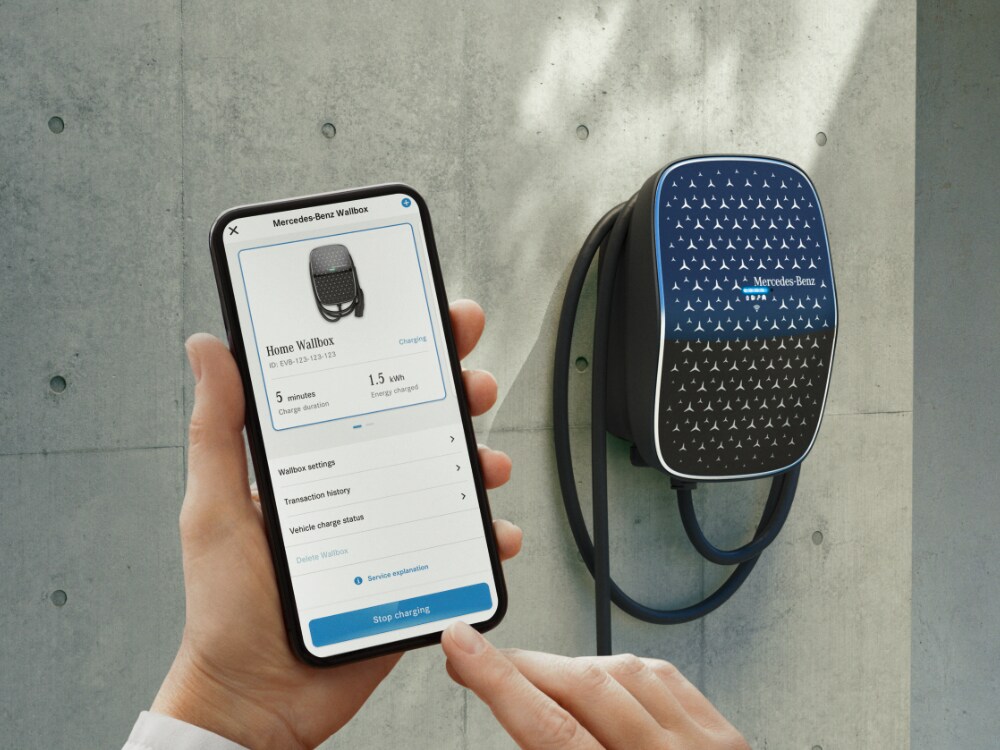 Ruka drží chytrý telefón na ovládanie nabíjacej skrinky Mercedes-Benz.