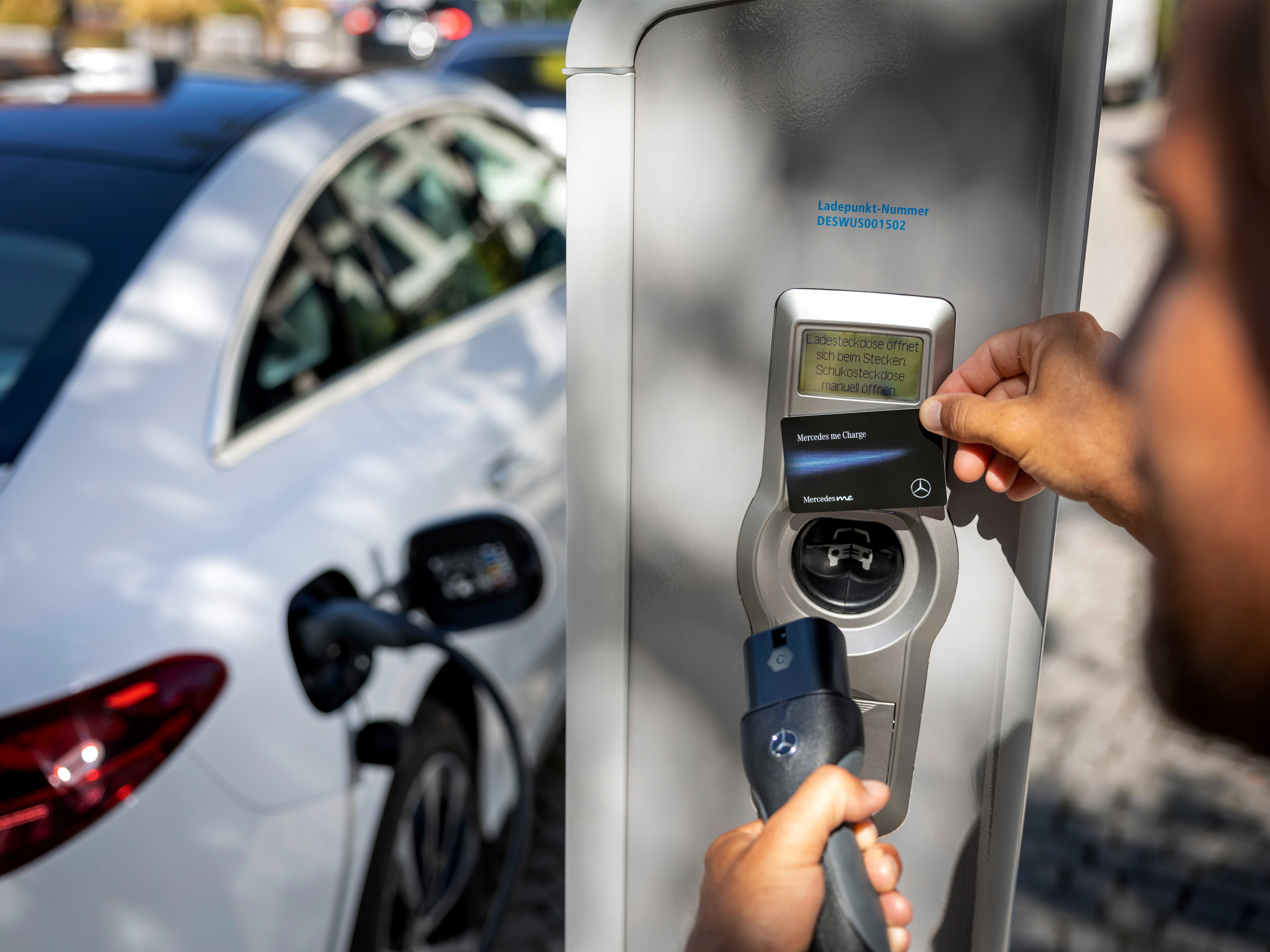 Muž nabíja elektrické vozidlo Mercedes-Benz na nabíjacej stanici Ionity