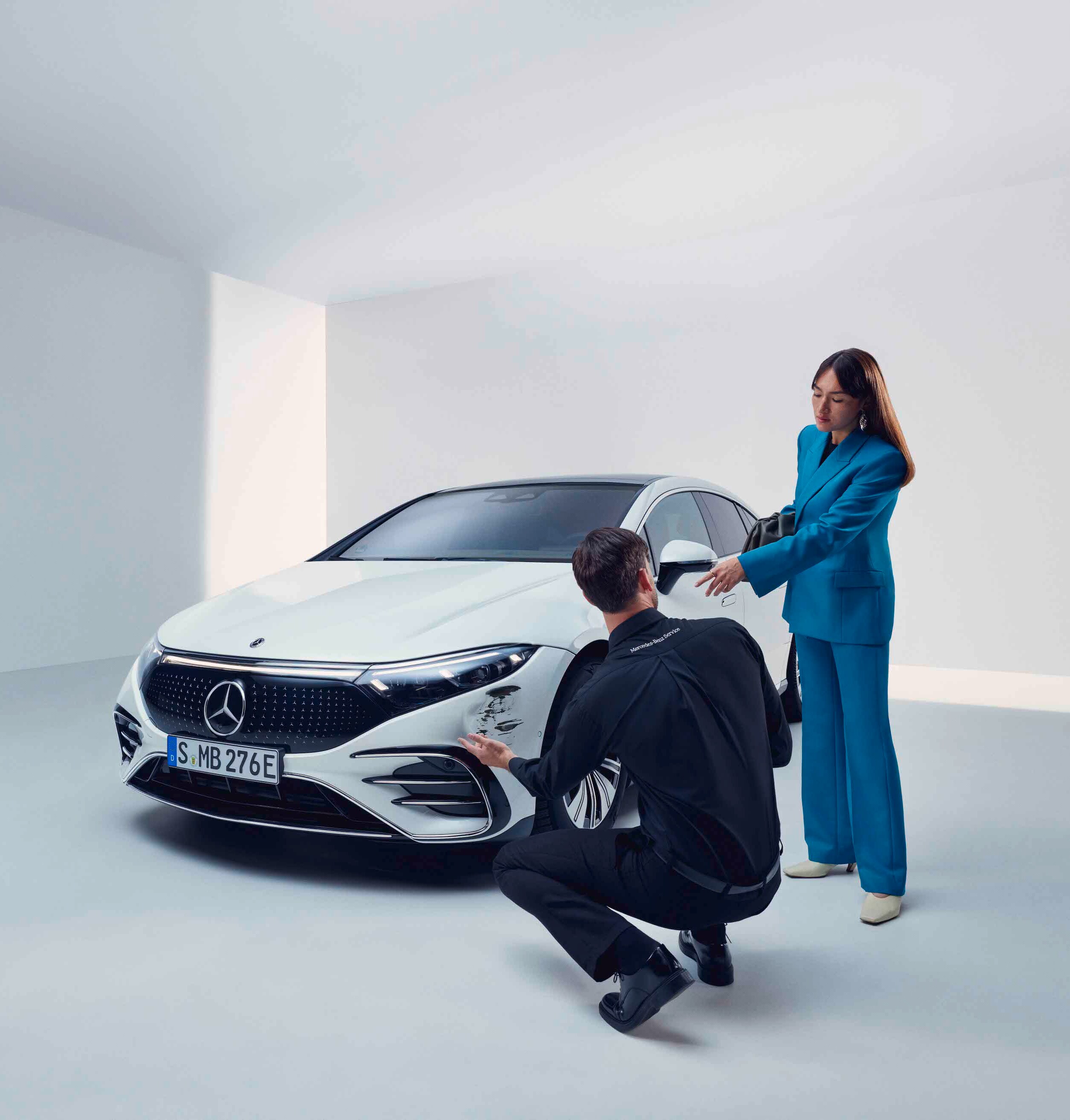 Žena necháva svoje vozidlo Mercedes-Benz skontrolovať servisným pracovníkom.