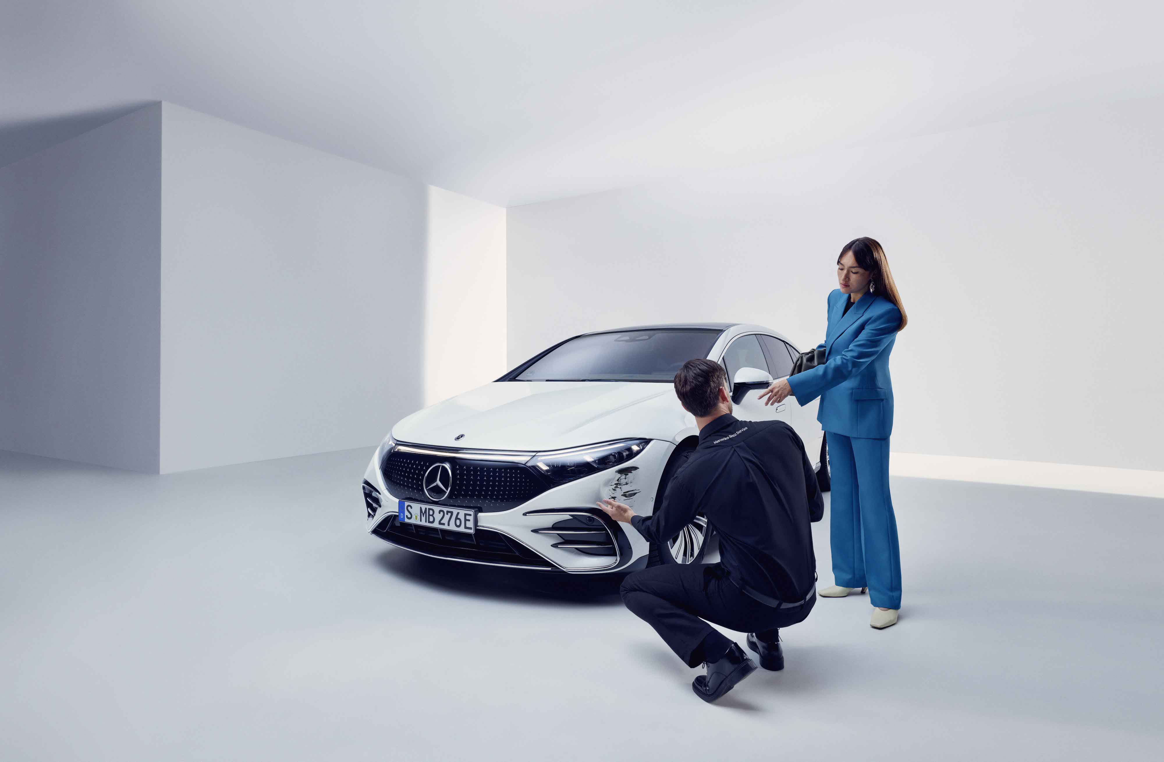 Pomoc pri poškodeniach | Mercedes-Benz Žena necháva svoje vozidlo Mercedes-Benz skontrolovať servisným pracovníkom.