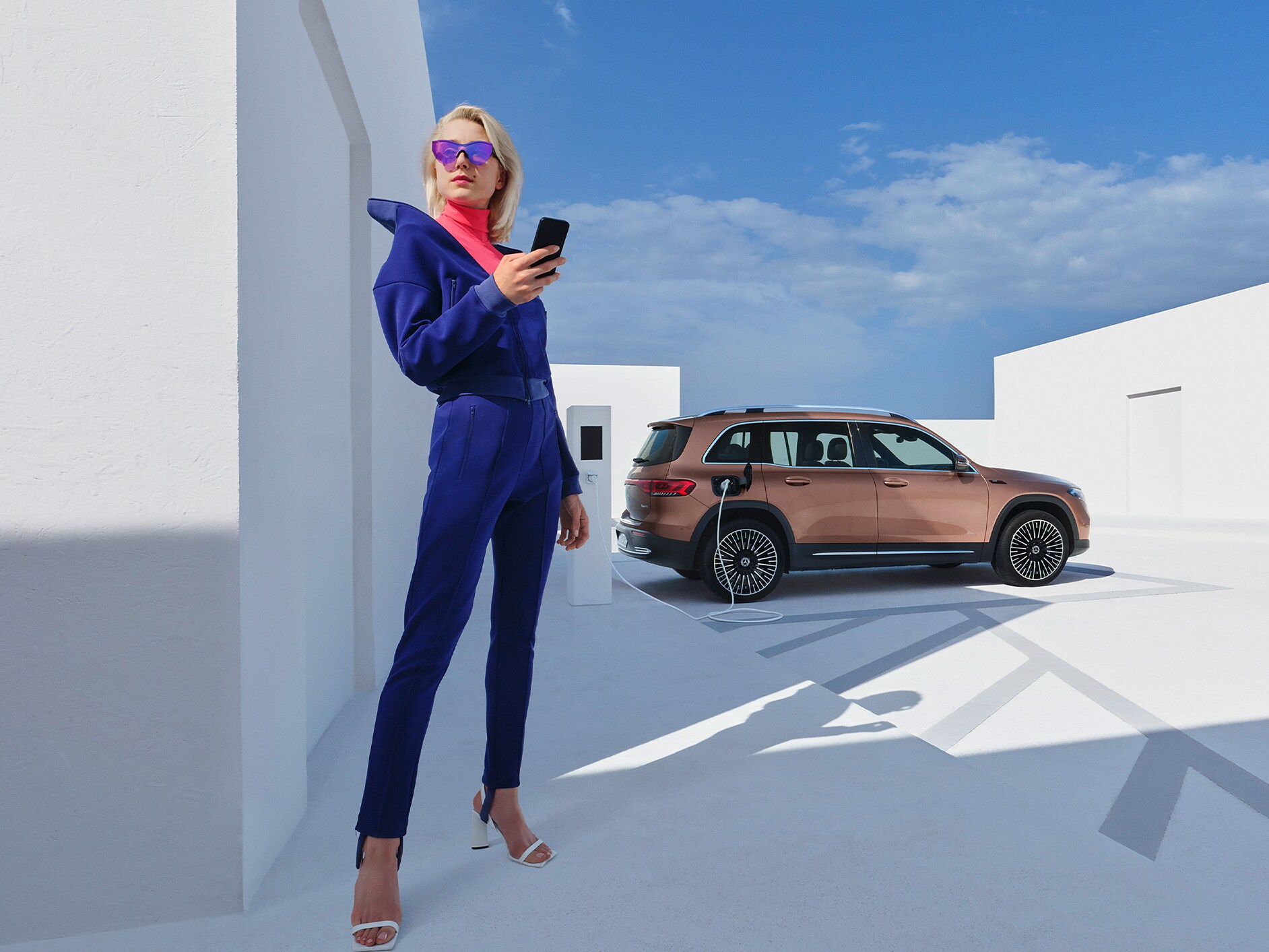 Žena prepája svoj chytrý telefón so svojím vozidlom, aby mohla využívať základné služby.