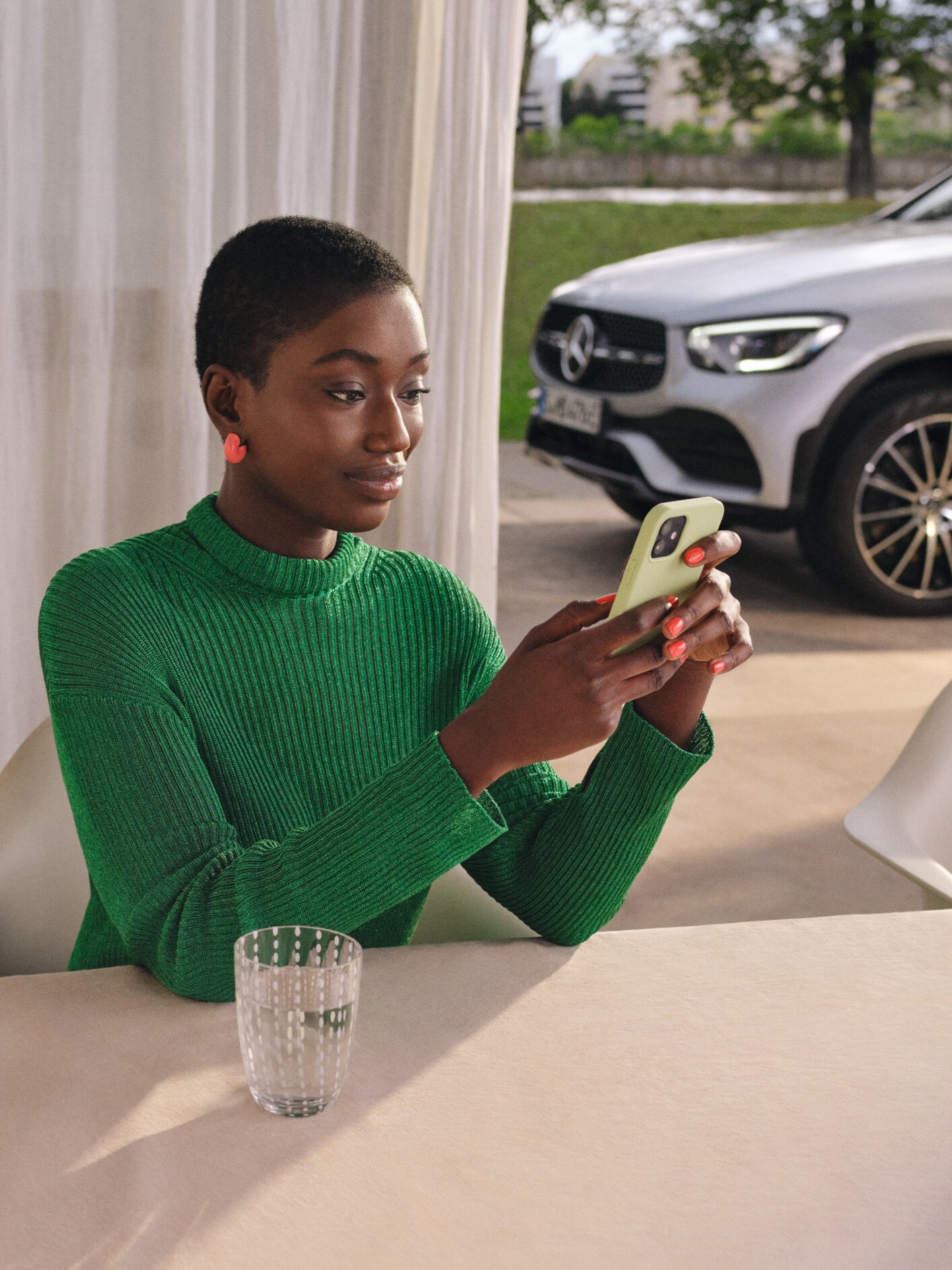 Žena pomocou chytrého telefónu kontroluje stav svojho vozidla.