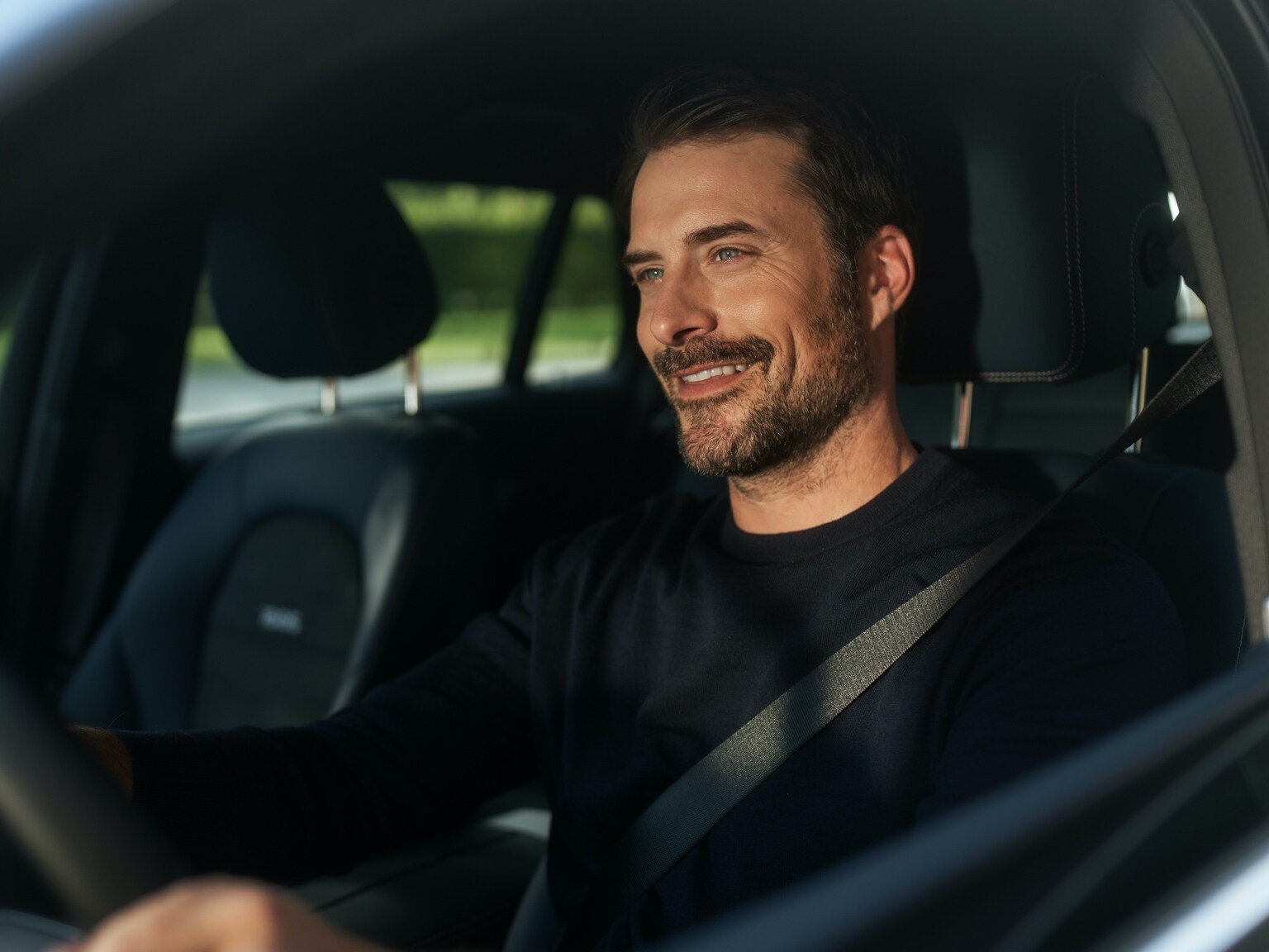 Muž si vo svojom vozidle Mercedes-Benz vychutnáva internetové rádio bez prerušovania vďaka balíku zábavy.