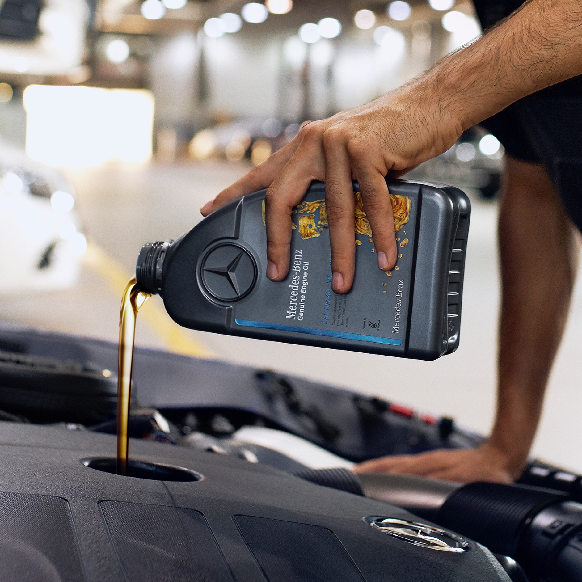 Motorový olej | Mercedes-Benz Osoba nalieva motorový olej do vozidla Mercedes-Benz.