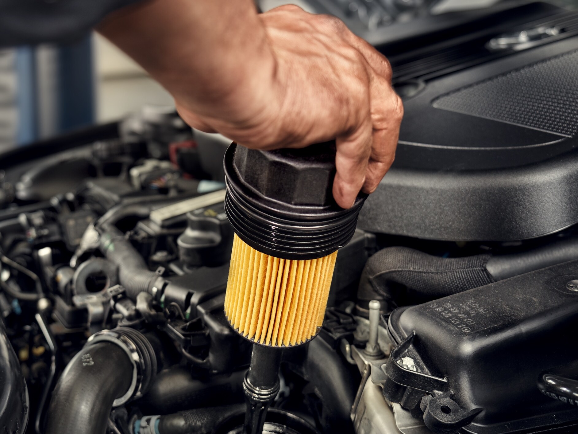 Technik montuje filter oleja do vozidla Mercedes-Benz.