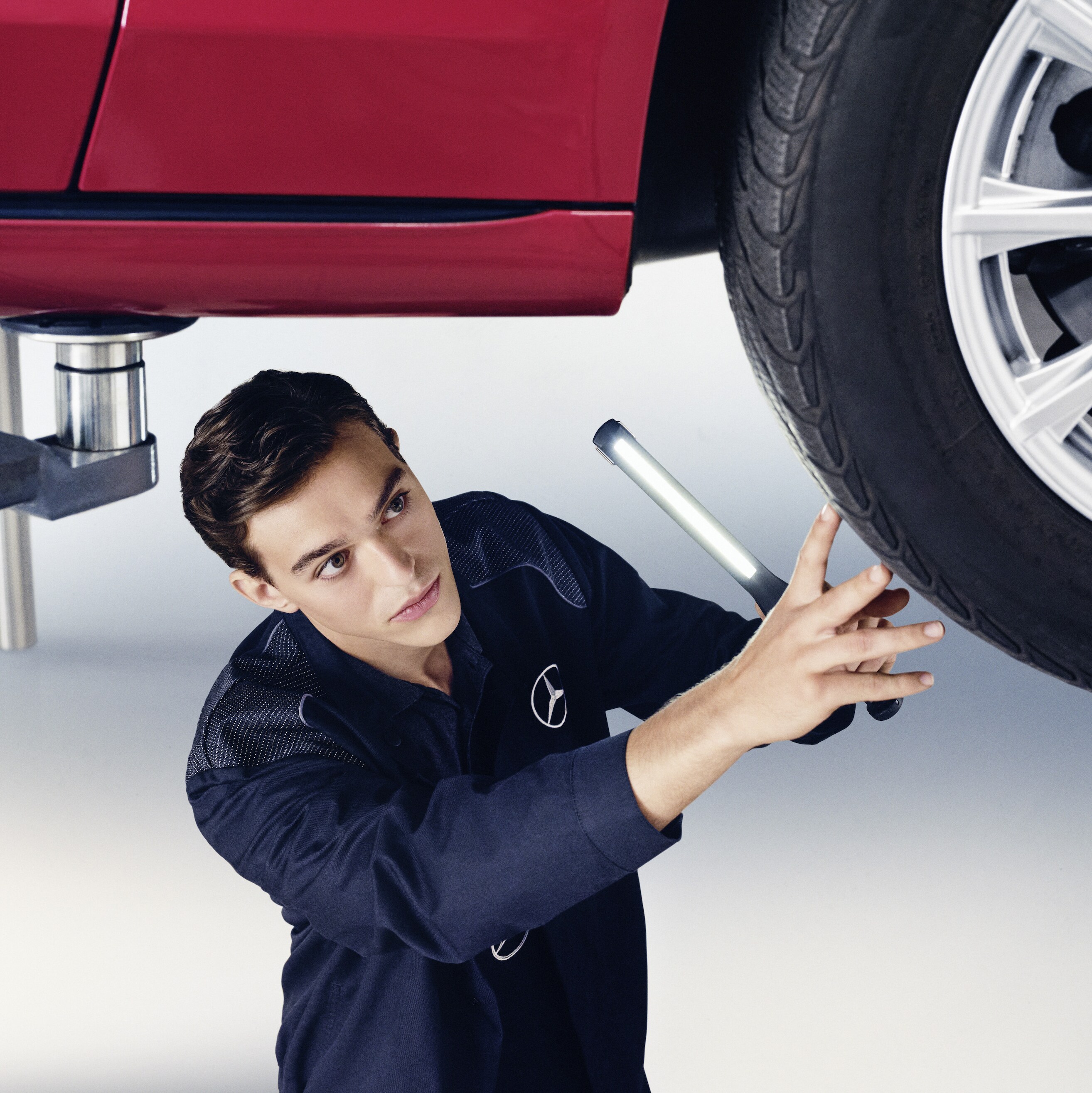 Technik Mercedes-Benz kontroluje spodok vozidla.