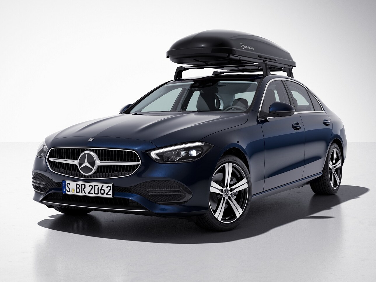 Čierny strešný box Mercedes-AMG je namontovaný na streche modrého vozidla Mercedes-Benz.