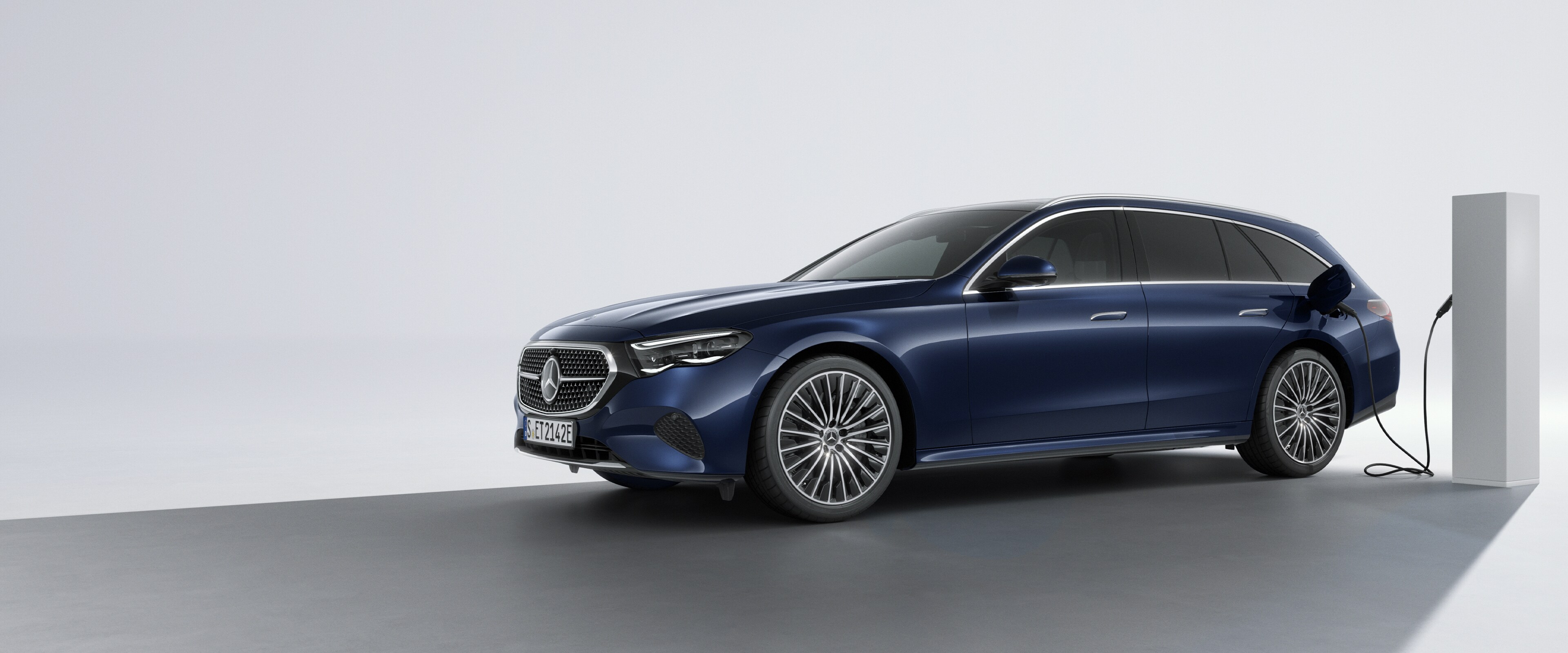 Hybridné vozidlo dobíjateľné zo siete od značky Mercedes-Benz pri bočnom pohľade zozadu na nabíjacej stanici.