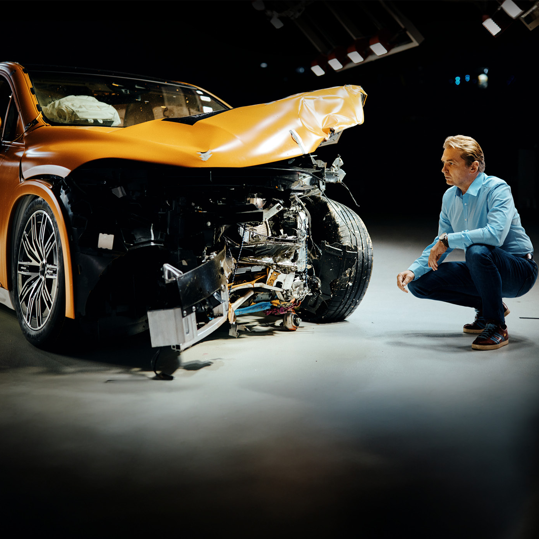 Experti na nárazové testy | Bezpečnosť | Mercedes-Benz Expert na nárazové testy v kľaku skúma vozidlo Mercedes-Benz po čelnom náraze.