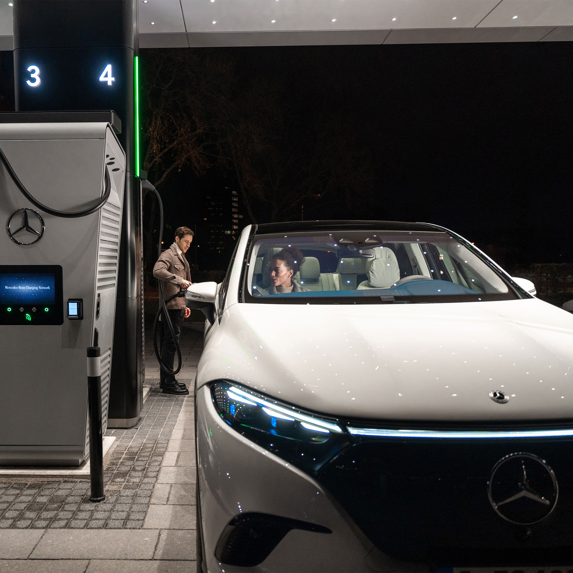 Riešenia nabíjania | Technológie | Mercedes-Benz Mercedes-Benz CLA stojaca na ulici, pripojená k nabíjaciemu stojanu.