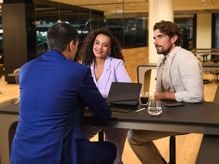 Prenájom | Finančné služby | Mercedes-Benz transportér Traja ľudia sediaci na stole sa zapájajú v diskusii.