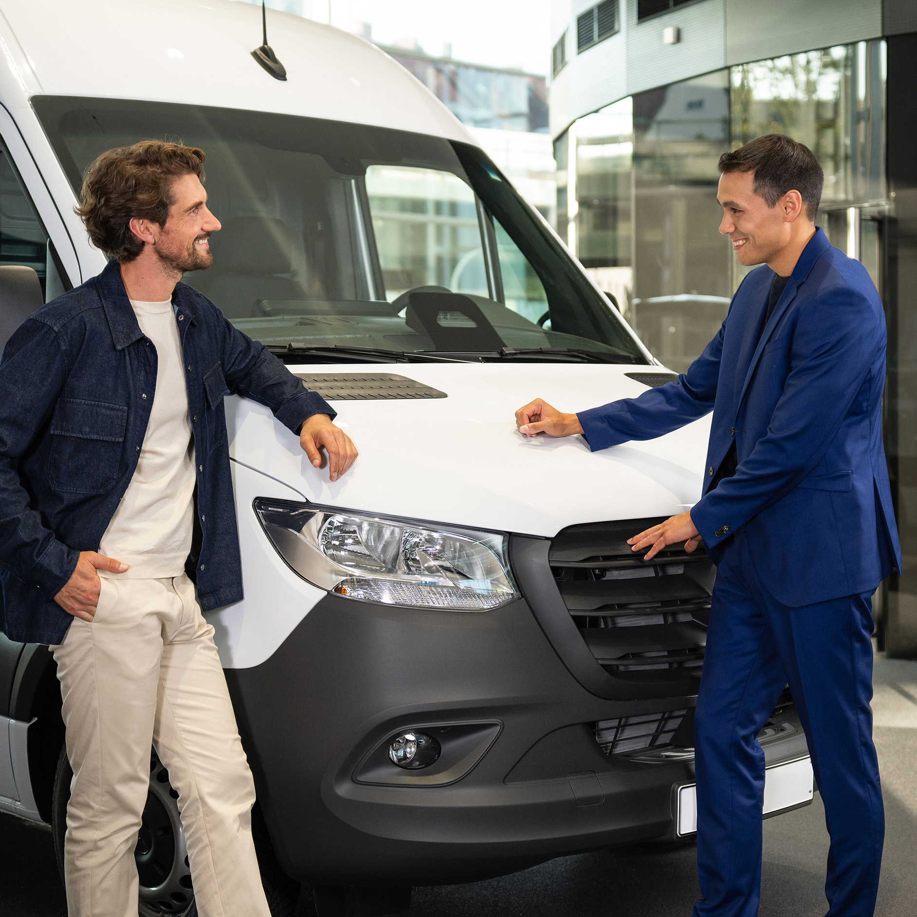 Operativní leasing | Finanční služby | Mercedes-Benz Dvaja ľudia, ktorí sa opierajú o dodávku Mercedes-Benz a majú rozhovor.