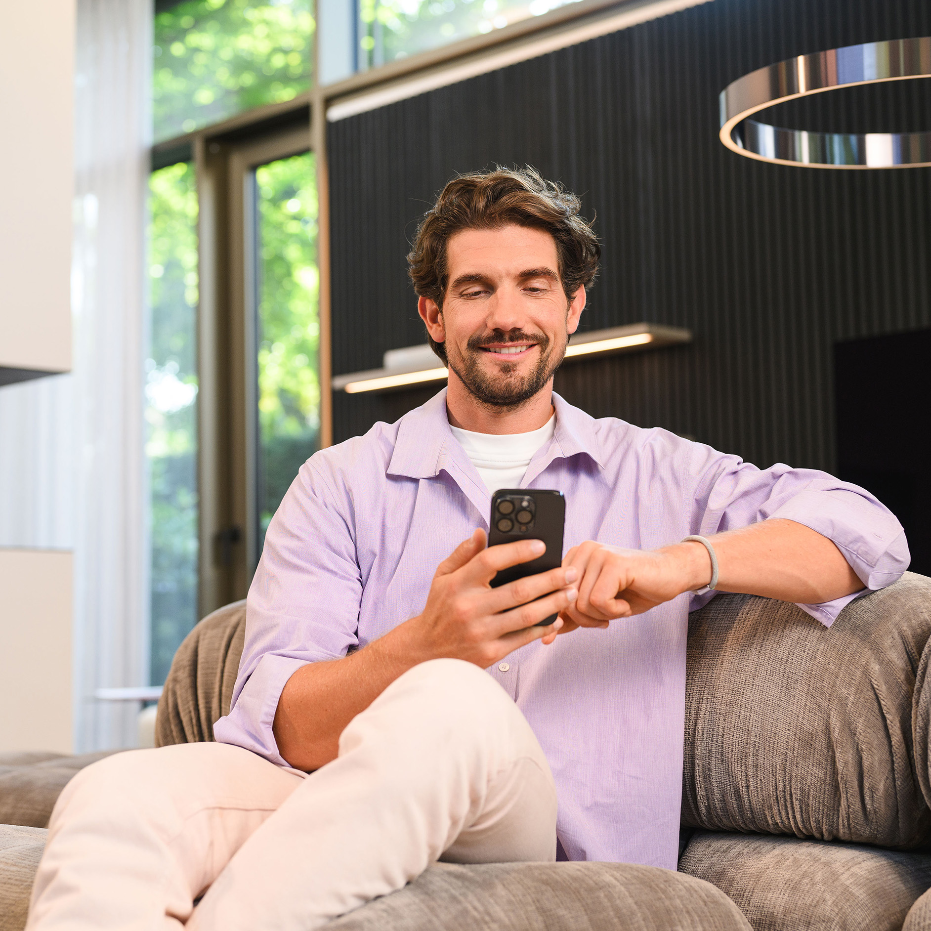 Operativní leasing | Finanční služby | Mercedes-Benz Osoba sediaca na pohovke a používajúca mobilné zariadenie.