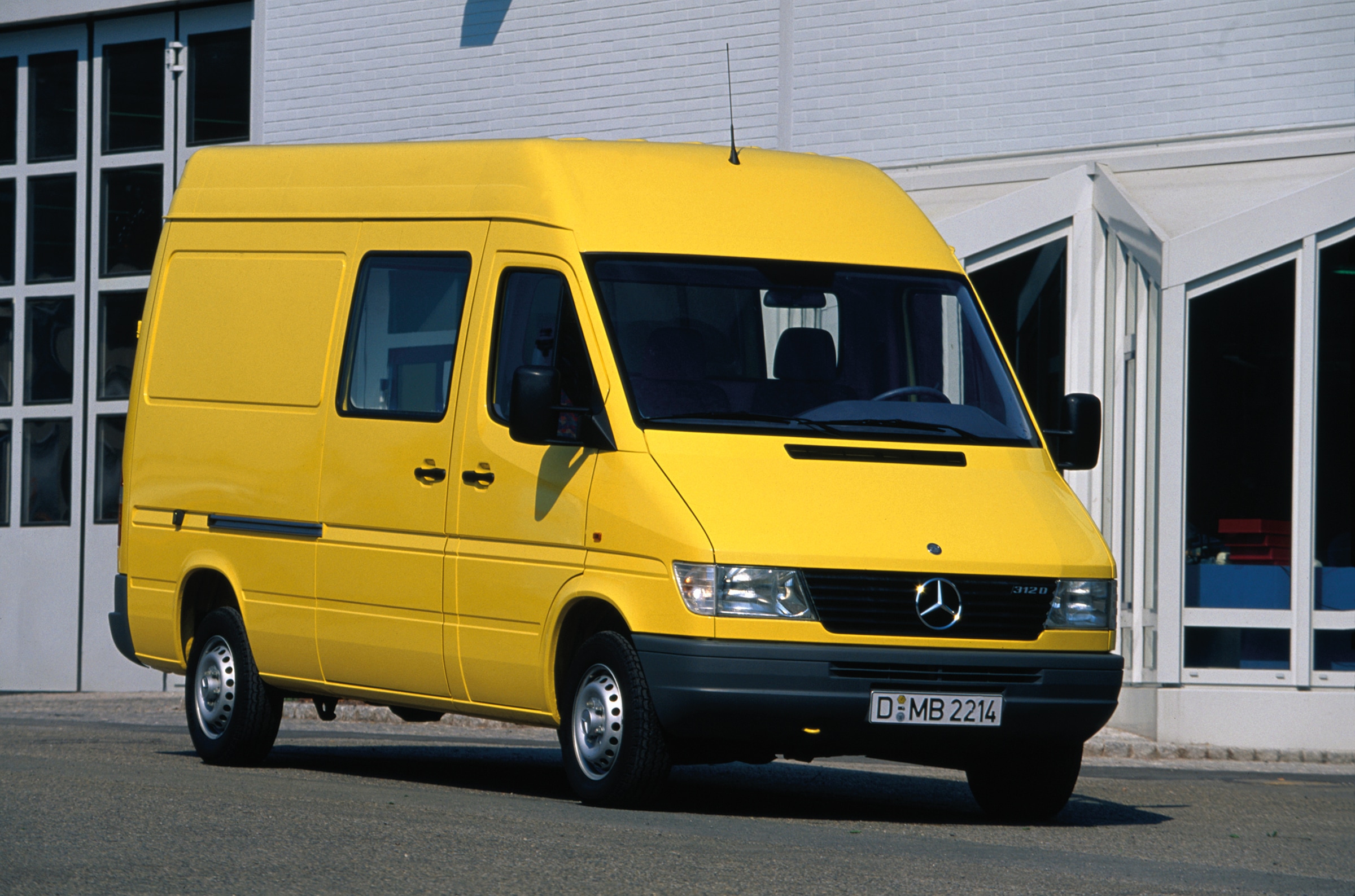 Prvá generácia vozidiel Mercedes-Benz Sprinter | História úžitkových vozidiel | Mercedes-Benz Sprinter prvej generácie zaparkovaný pred priemyselnou budovou