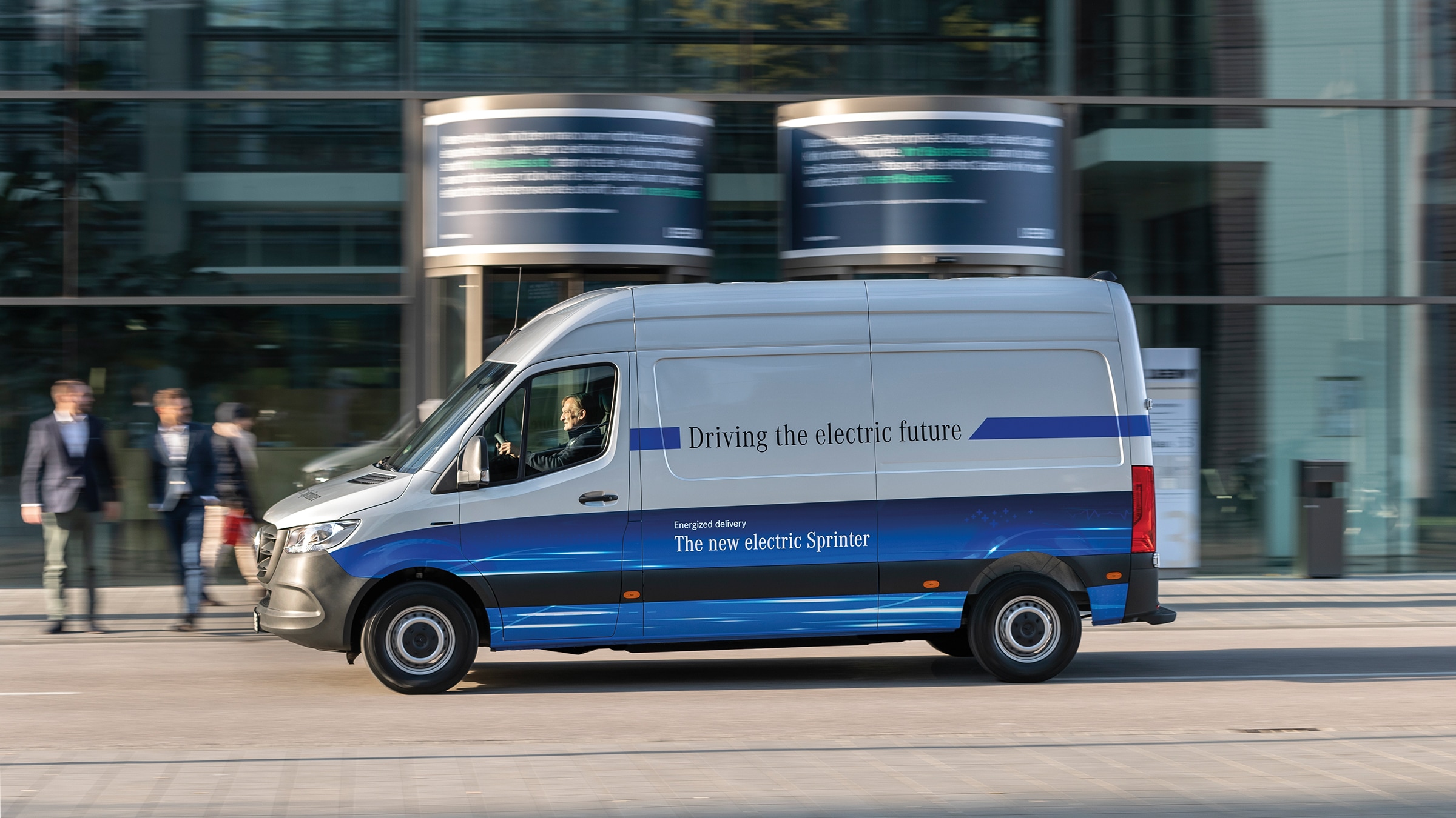 Druhá generácia skriňového vozidla eSprinter | História úžitkových vozidiel | Mercedes-Benz Skriňová dodávka Mercedes-Benz eSprinter jazdí po modernej mestskej ulici
