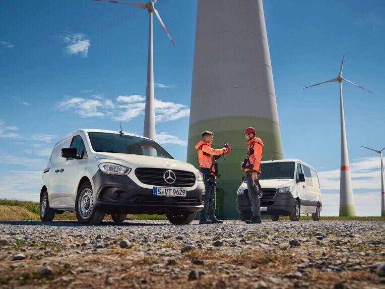 Tím Mercedes-Benz ServiceCare pozostávajúci z dvoch robotníkov a ich transportérov pred solárno-veterným systémom.