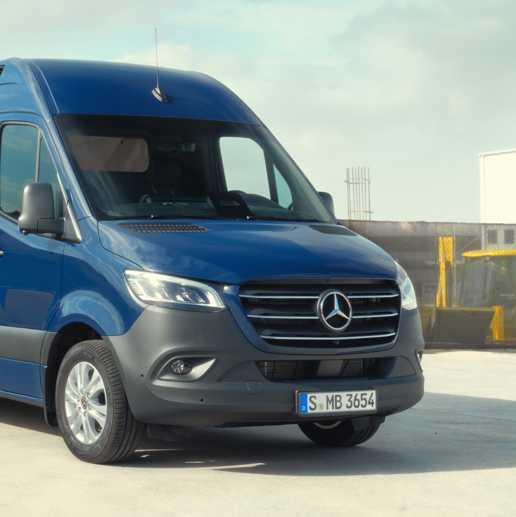Skriňové vozidlo Mercedes-Benz Sprinter pred stavebným materiálom.