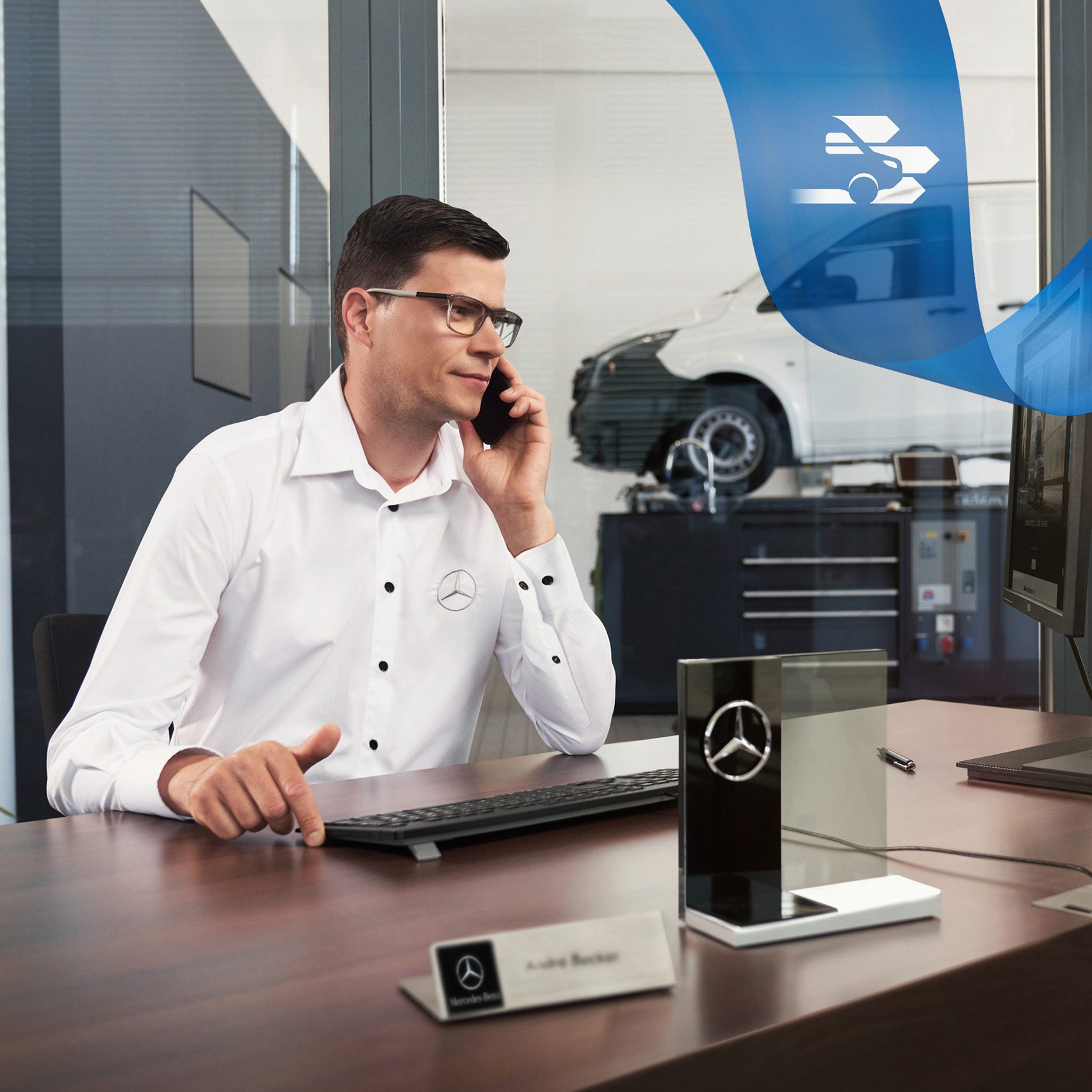 Mercedes-Benz | Starostlivosť o úžitkové vozidlá | Poruchová služba Zamestnanec za stolom telefonuje, v pozadí úžitkové vozidlo Mercedes-Benz Vito v dielni.