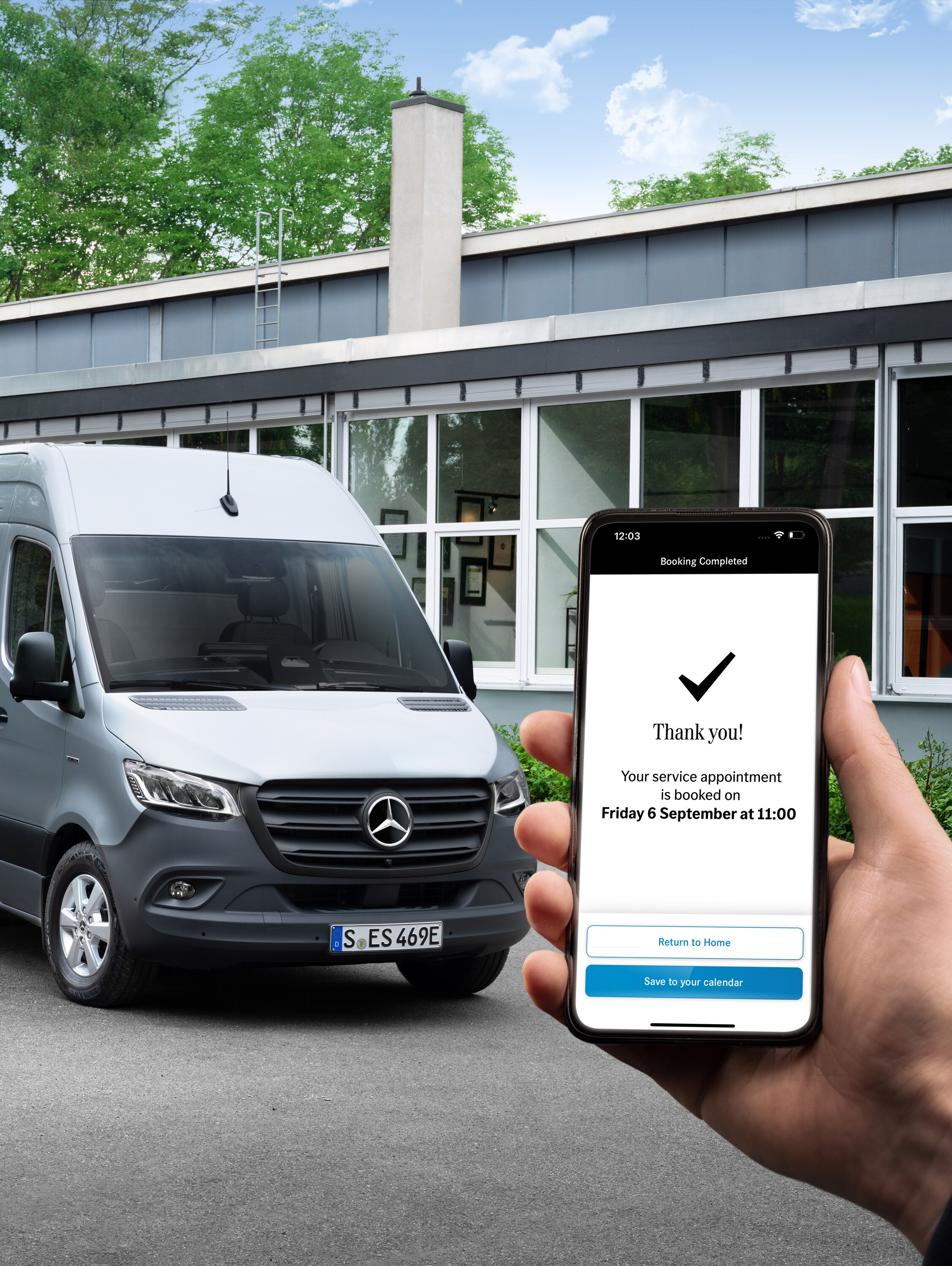 Sivé úžitkové vozidlo Mercedes-Benz Sprinter pred kanceláriou, v popredí osoba s telefónom v ruke.