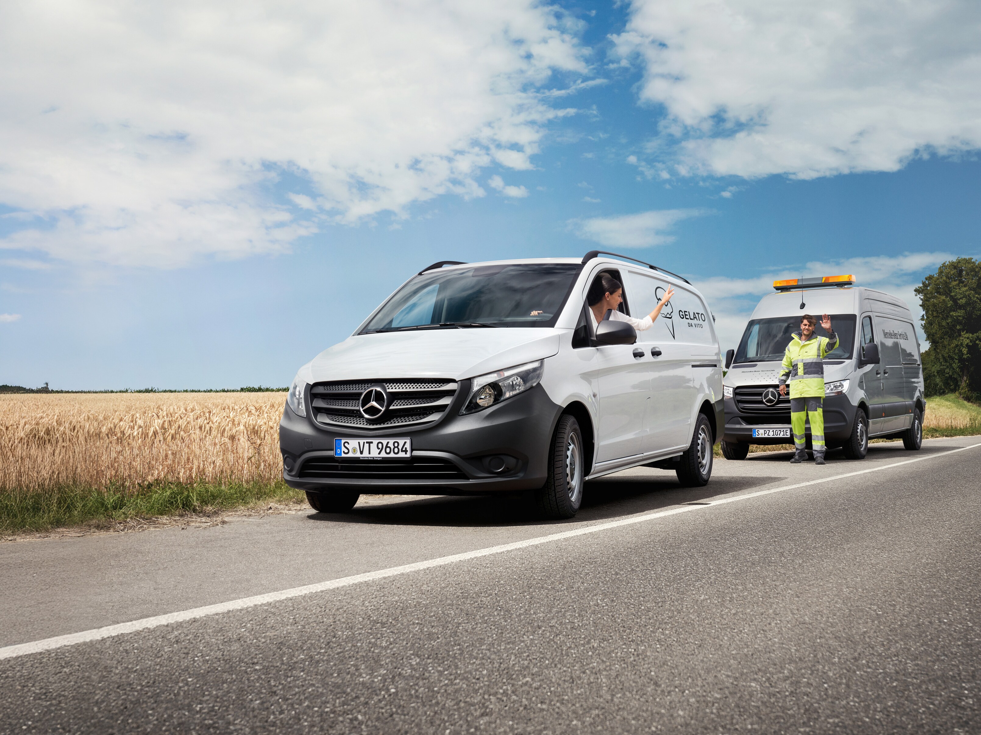 Žena sediaca v&nbsp;bielom vozidle Mercedes-Benz Vito máva na servisného technika Mercedes-Benz na okraji cesty.