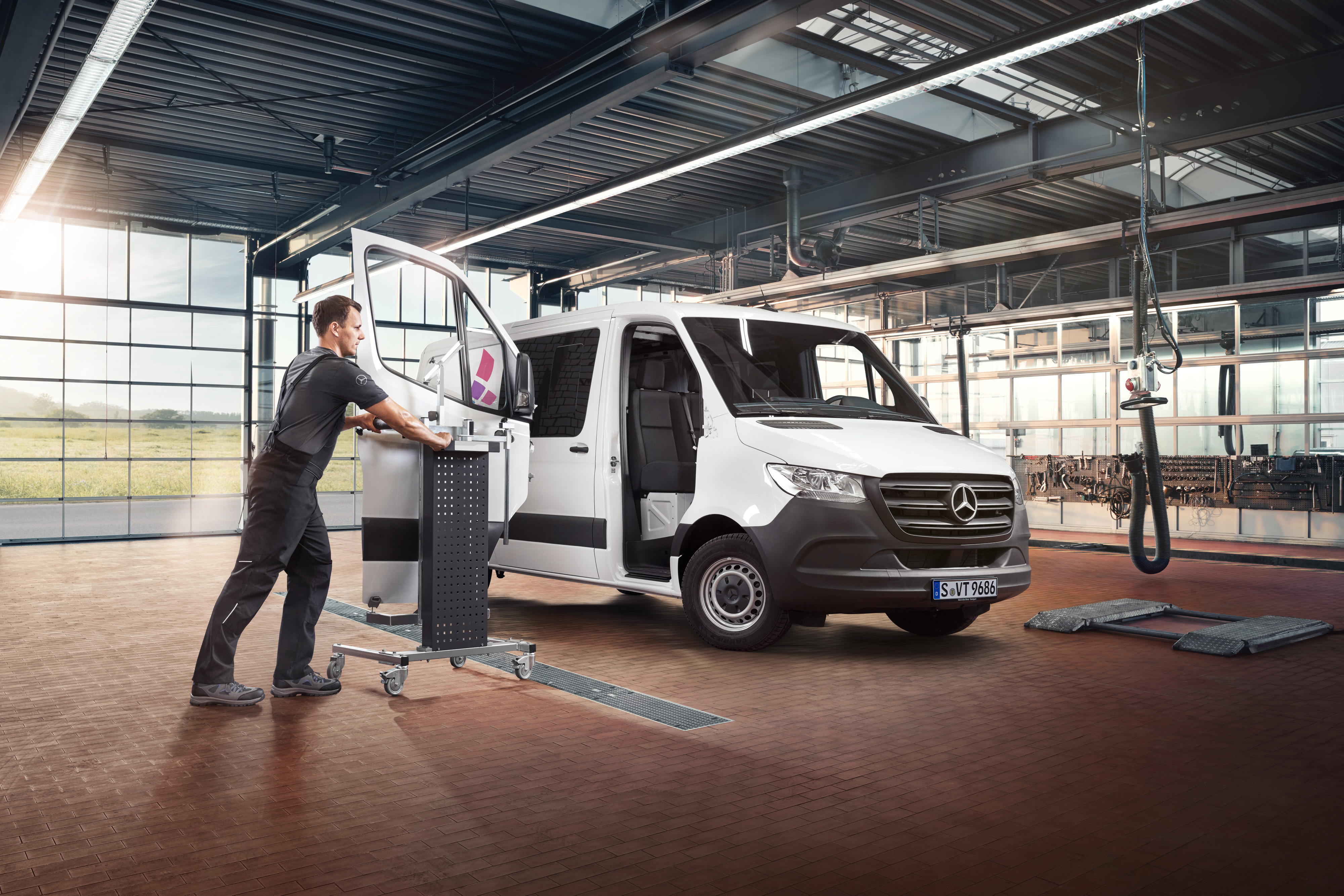 Mercedes-Benz | Prehľad služieb | Oprava Technik vykonáva údržbu dverí spolujazdca na bielom úžitkovom vozidle Mercedes-Benz Sprinter.