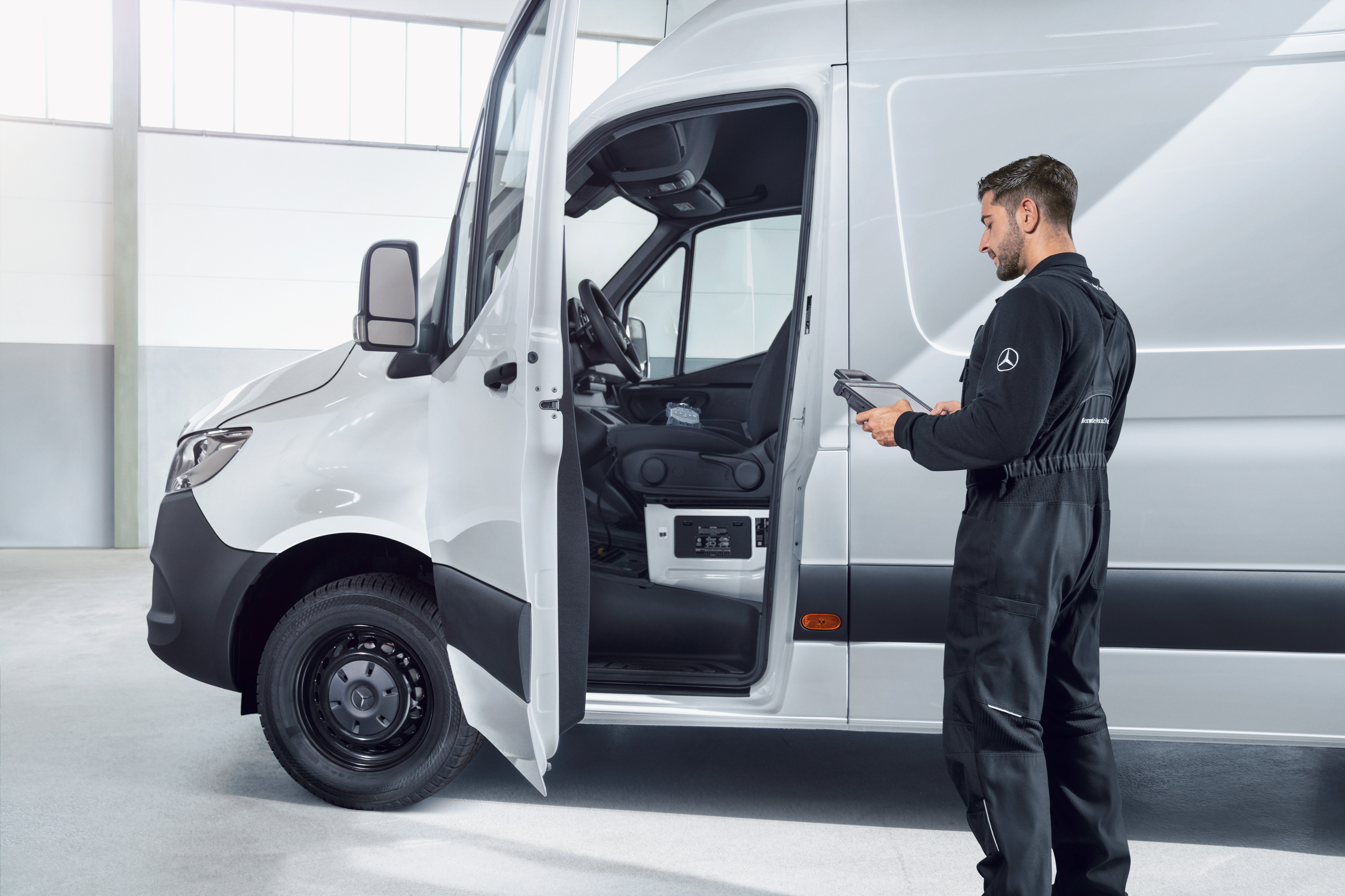 Mercedes-Benz | Prehľad služieb | Údržba vozidla Zamestnanec kontroluje úžitkové vozidlo Mercedes-Benz, pričom poskytuje spoľahlivé a kvalitné služby v oblasti údržby a opráv.