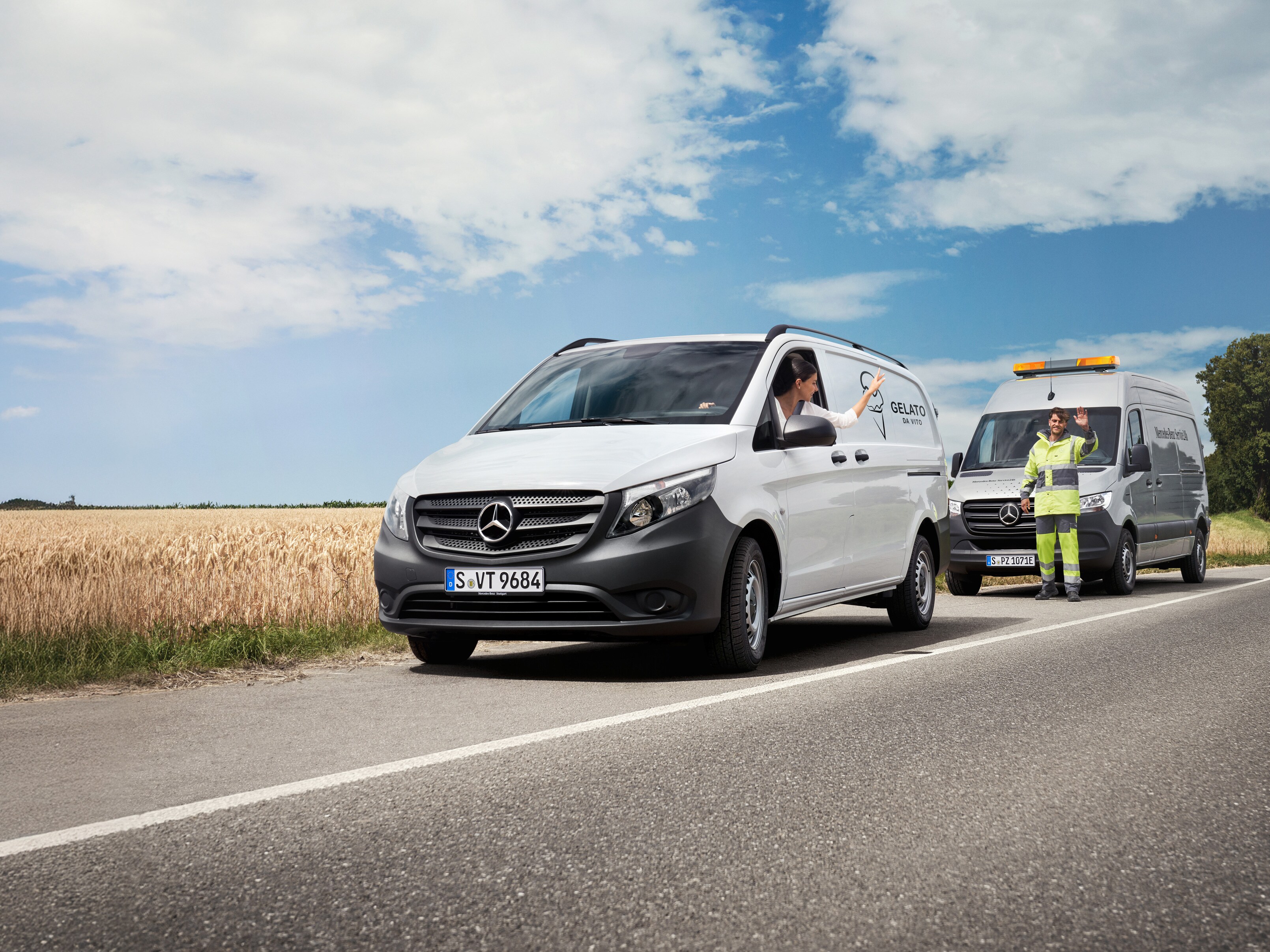 Mechanik z poruchovej služby poskytuje pomoc zákazníkovi v bielom úžitkovom vozidle Mercedes-Benz Vito.