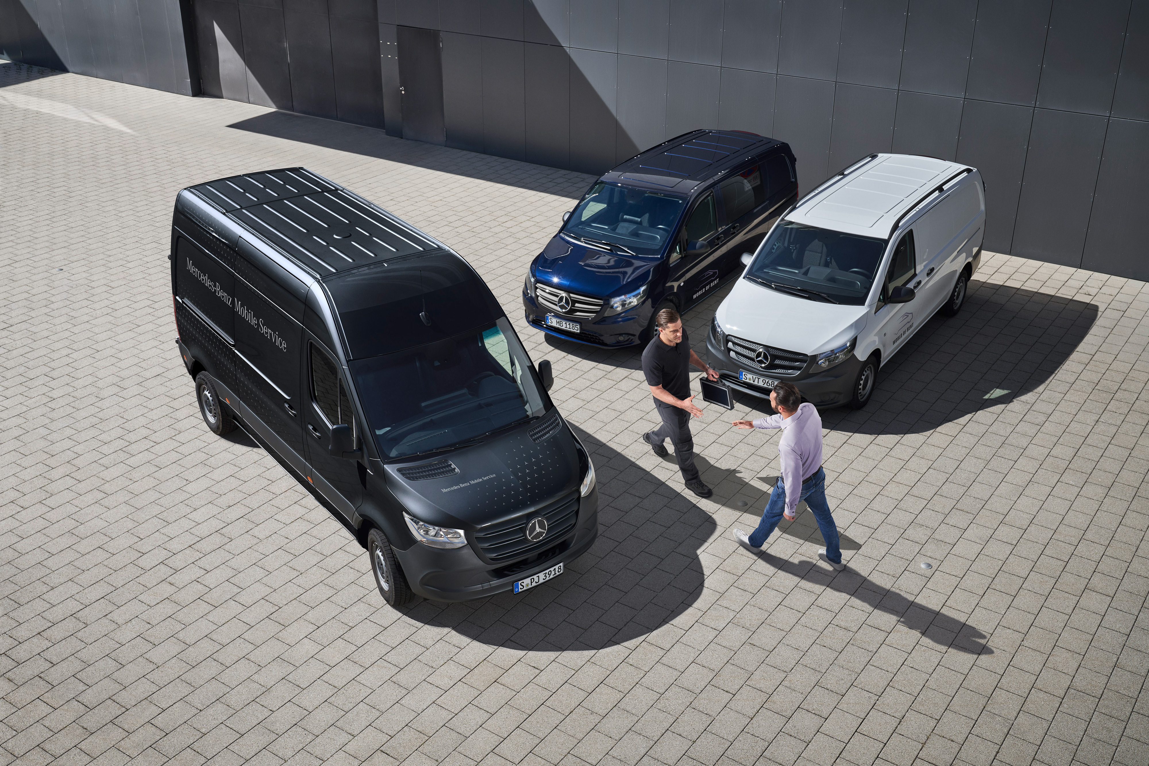 Mercedes-Benz | Prehľad služieb | Mobilný servis Dvaja muži sa zdravia medzi úžitkovými vozidlami Mercedes-Benz.
