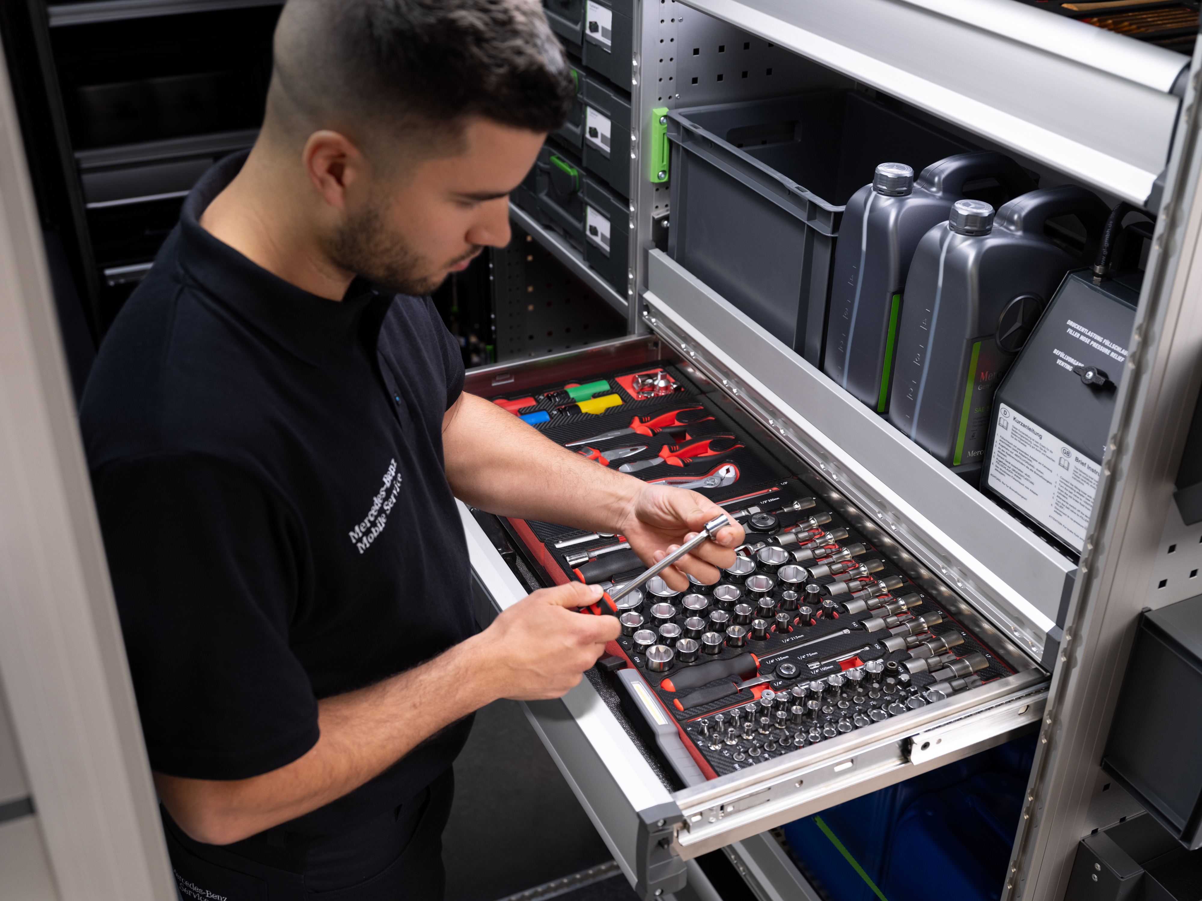 Mercedes-Benz | Mobilný servis | Elektronika Technik vyberá predmet zo zásuvky plnej náradia.