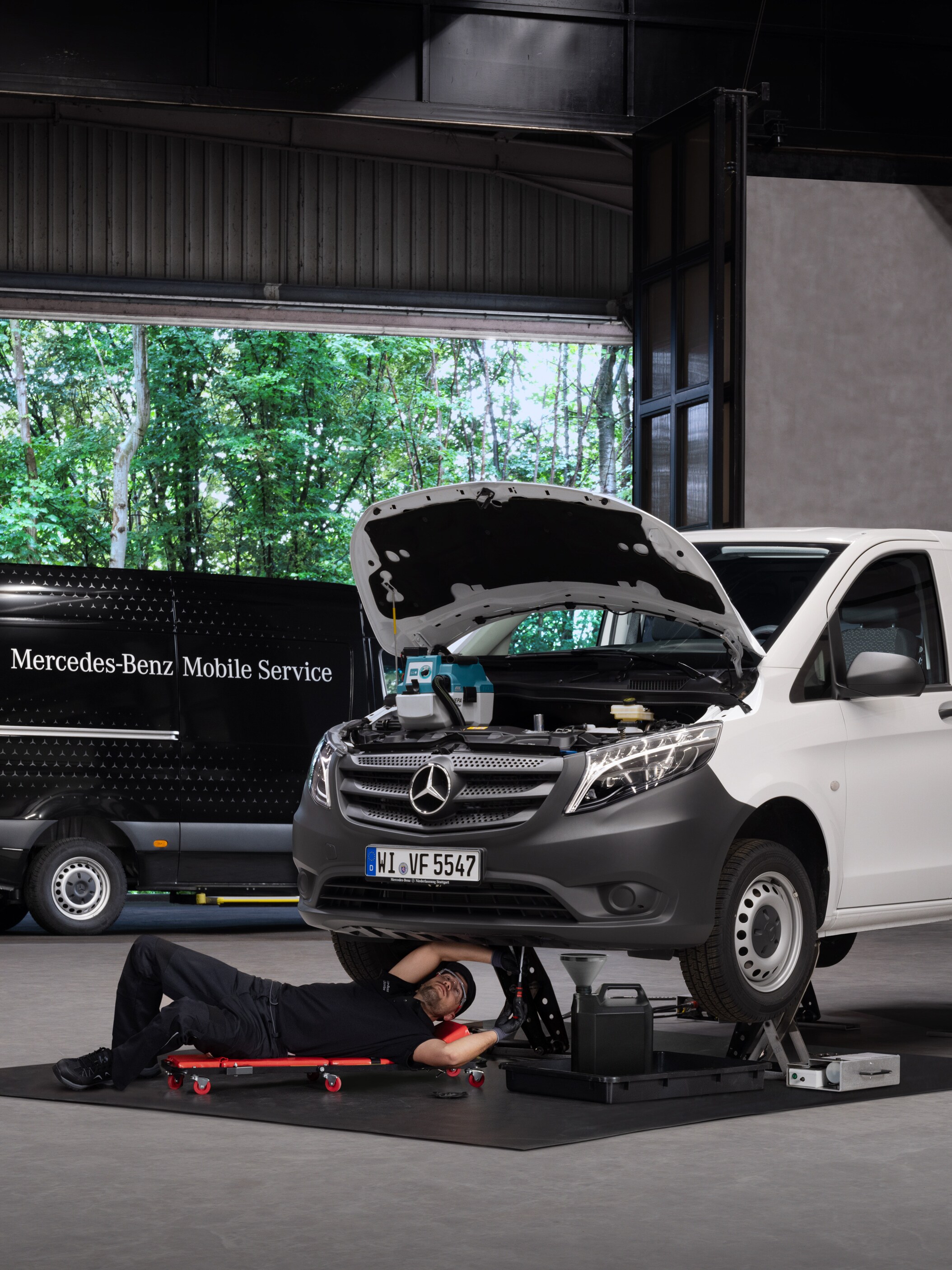 Technik opravuje biele úžitkové vozidlo Mercedes-Benz Vito.