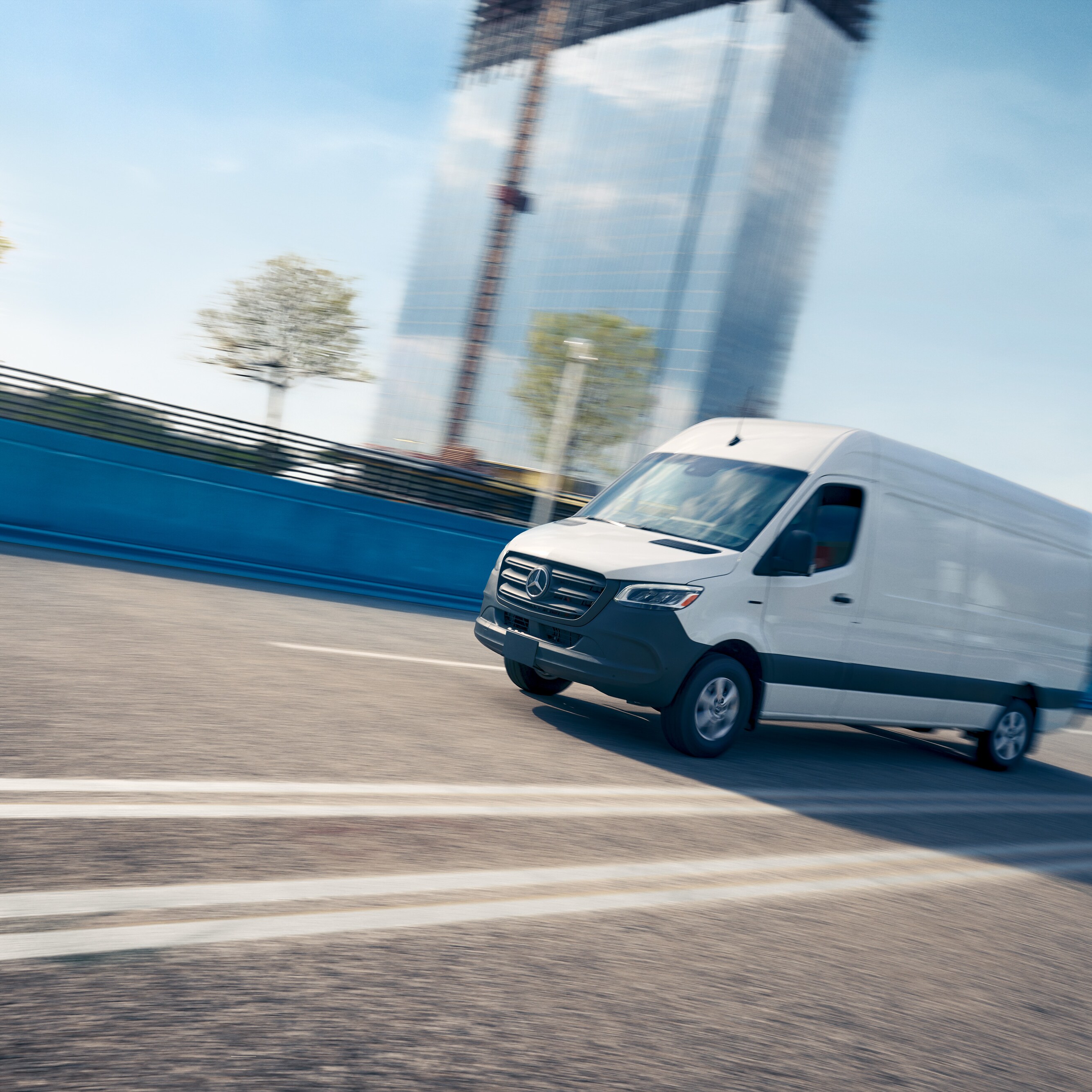 Biele úžitkové vozidlo jazdí po ceste, reklama na servisnú aplikáciu Mercedes-Benz s online rezerváciou termínu.