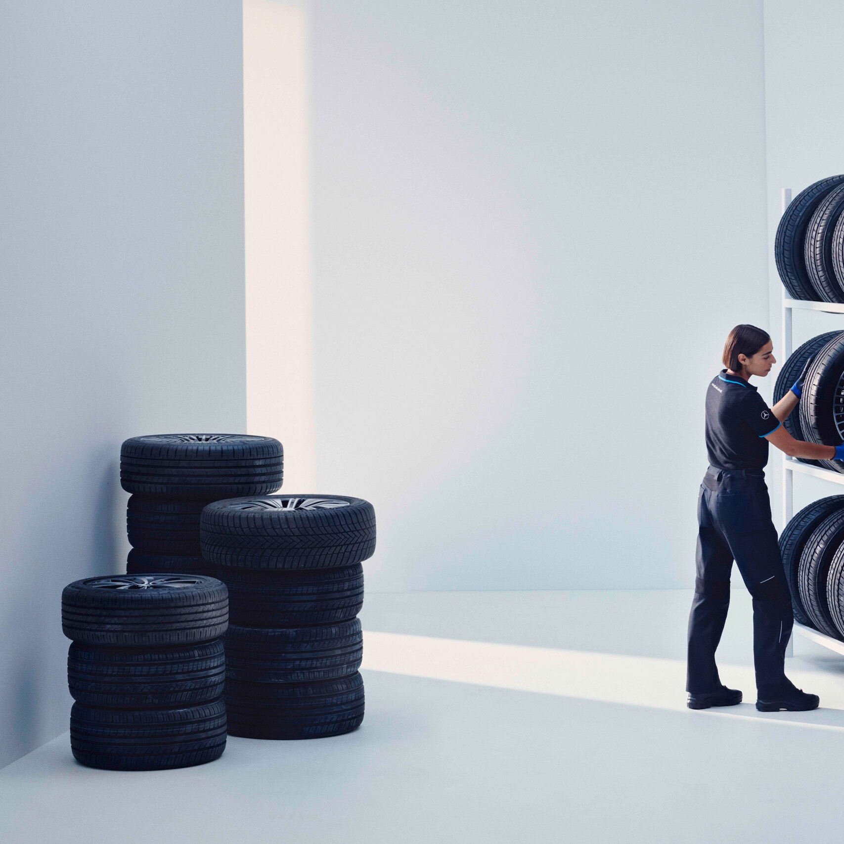 Technik Mercedes-Benz ukladá pneumatiky Mercedes-Benz Original na regál.